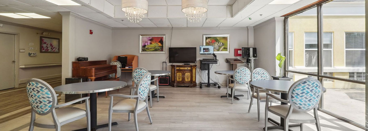 Long-Term care room with TV and chairs with tables
